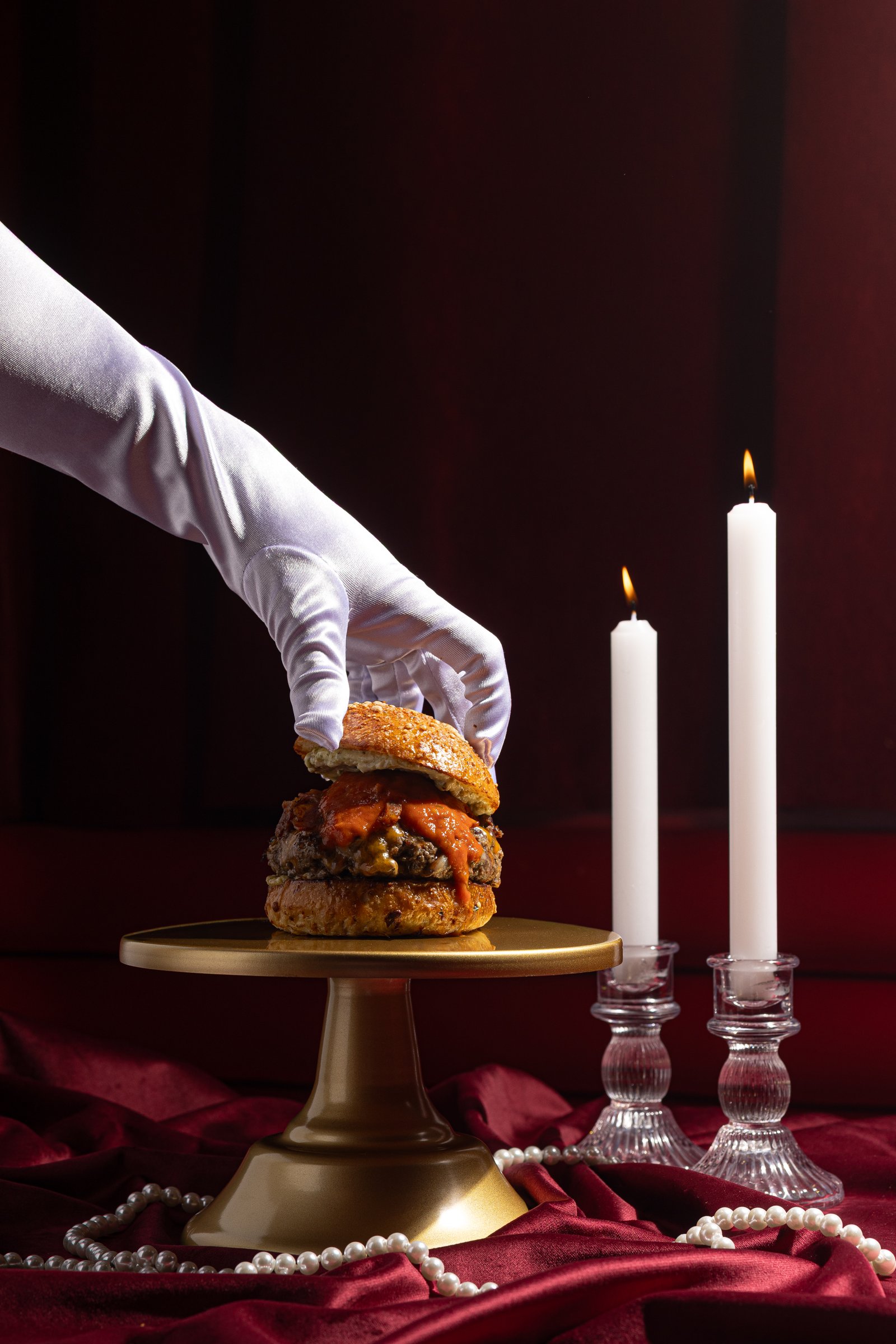 Macro extremo de hamburguesa Burgaccia con focaccia dorada y salsa roja brillante cayendo sobre el queso fundido