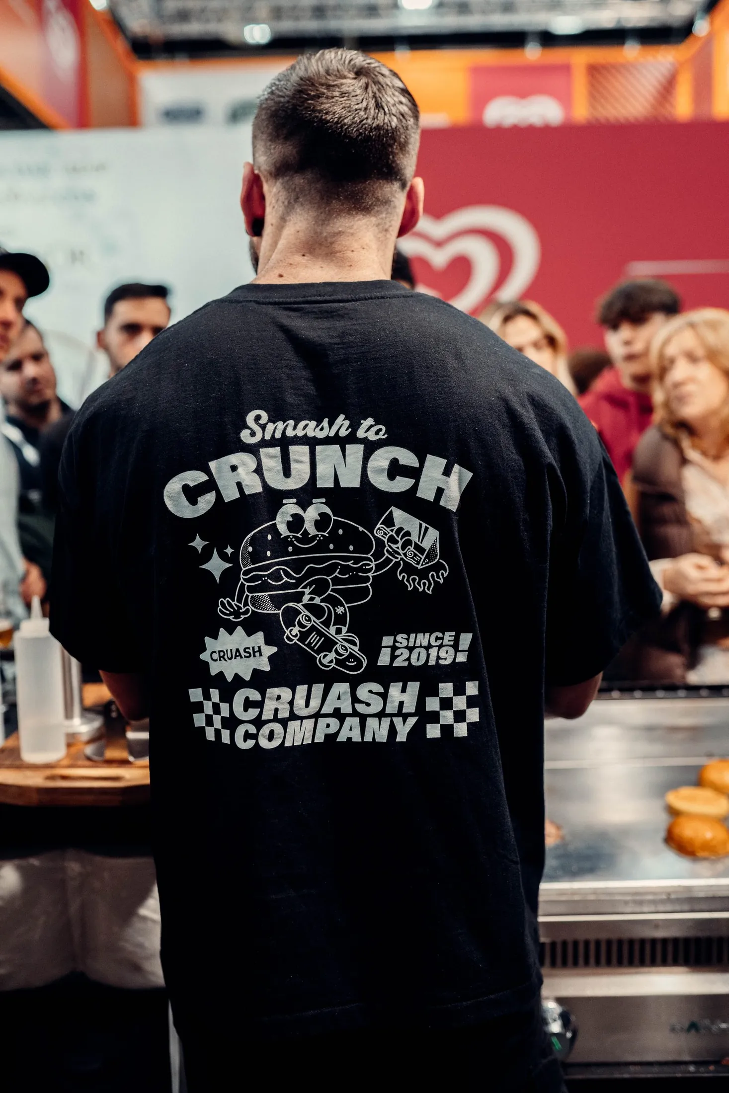 T-shirt del merchandising CRUASH con mascot Smash to Crunch y tagline CRUASH COMPANY SINCE 2019 en la espalda